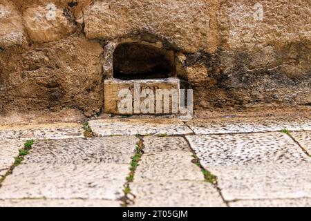 una ciotola in pietra per cani del xvi secolo con iscrizione latina amor di cani per l'amore dei cani nel muro di strada in pietra a sibenik Foto Stock