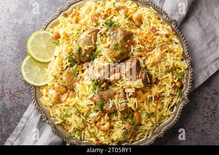 Delizioso Kacchi Biryani caldo con noci, uvetta, primi piani di cipolla fritta sul piatto sul tavolo. Vista superiore orizzontale dall'alto Foto Stock