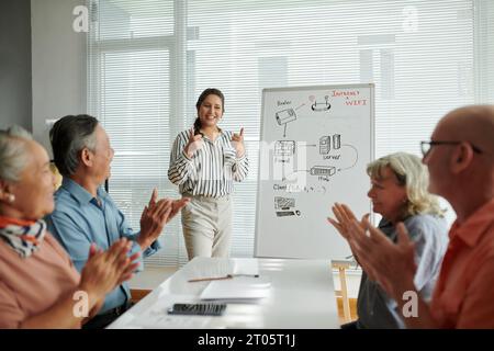 Studenti anziani applaudono e applaudono insegnante di classe di computer Foto Stock