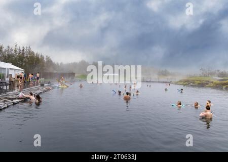 Sorgenti termali islandesi - persone che fanno il bagno nella Laguna segreta, una piscina termale geotermale con acqua calda naturale, da energia termica, Reykjavik, Islanda. Foto Stock