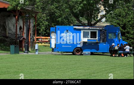 Gente che pranza a un tavolo da picnic vicino al food truck Brother Shucker nel Marine Park a Rockport Harbor, Rockport, Maine Foto Stock