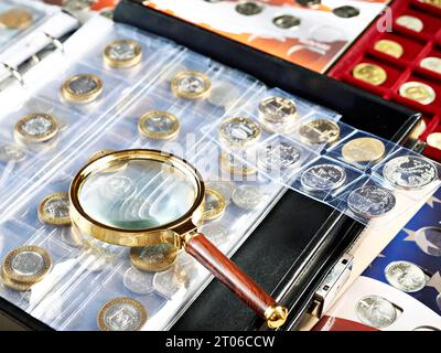 Raccolta di monete numismatiche. Album con lente di ingrandimento Foto Stock