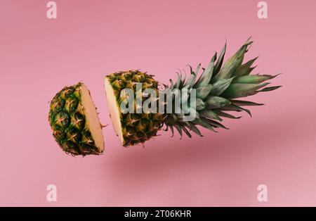 Ananas fresco a fette su sfondo rosa pastello. Concetto di frutta minimale. Idea creativa per il cibo estivo. Foto Stock