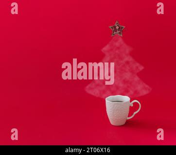 Albero di Natale composto da caffè o tè fumanti con stella a scacchi sulla parte superiore su sfondo rosso. Concetto di vacanza invernale. Layout per Capodanno minimo. Foto Stock