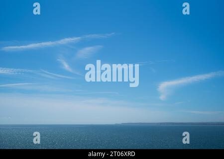orizzonte mare e cielo in una giornata con cielo blu e mare. Il molo di Deal e una penisola di terra possono essere visti all'orizzonte Foto Stock