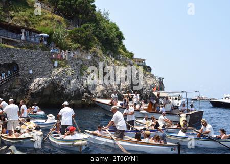 I turisti aspettano sulle barche a remi per entrare nella Grotta Azzurra, la più grande attrazione turistica dell'isola di Capri, a Napoli. Foto Stock
