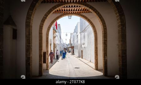 Rabat, Marocco - 9 settembre 2022: Gente del posto nelle strette stradine della città vecchia di Rabat, tutti edifici dipinti di bianco. Foto Stock