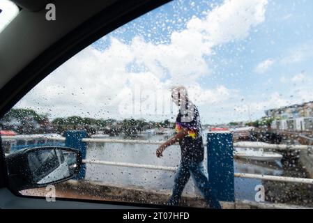 Valenca, Bahia, Brasile - 9 gennaio 2023: Si vedono persone camminare per strada in una giornata di pioggia intensa nella città di Valenca, Bahia. Foto Stock