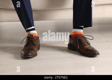 Uomo che indossa scarpe eleganti e calze colorate al chiuso, primo piano Foto Stock