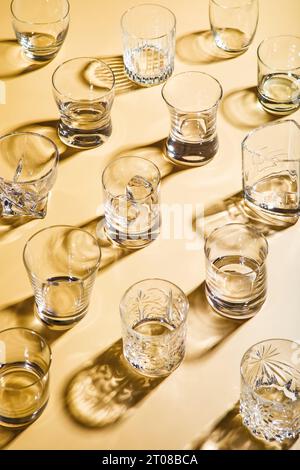 Vari bicchieri di whisky vuoti su sfondo dorato. Foto Stock