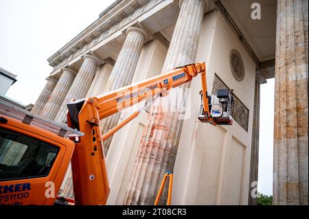 Berlino, Germania. 5 ottobre 2023. I dipendenti di un ristoratore dipingono le macchie di vernice di una precedente protesta di "ultima generazione" alla porta di Brandeburgo. Credito: Fabian Sommer/dpa/Alamy Live News Foto Stock