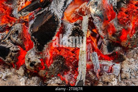 i carboni ardenti si chiudono di notte. Un fuoco rampicante con una brace di legno. Foto Stock