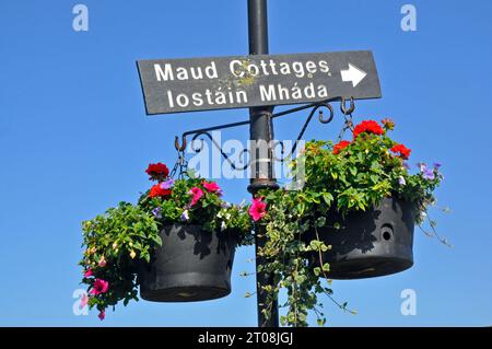 Un cartello per il lungomare 'Maud Cottages' nel paesino costiero panoramico di Cushendun, contea di Antrim, Irlanda del Nord. Foto Stock