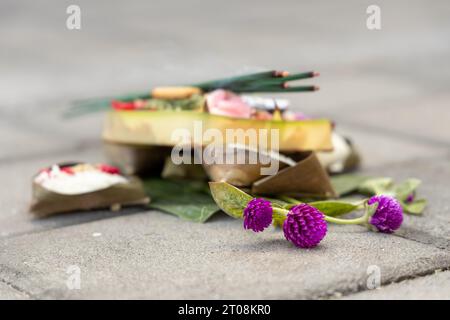 Un'offerta balinese o banten con incenso bruciato visibile Foto Stock