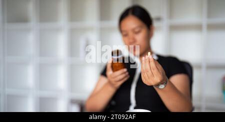 Primo piano donna che tiene la pillola in mano con l'acqua che si sente male. donna che sta per prendere antidolorifico da mal di testa, antidolorifico, assistenza sanitaria, medicina Foto Stock