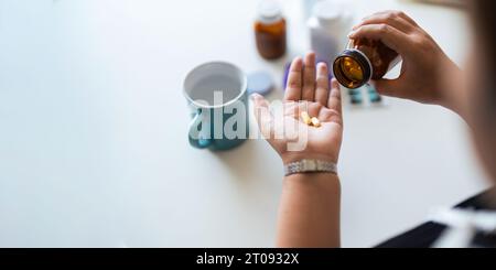 Primo piano donna che tiene la pillola in mano con l'acqua che si sente male. donna che sta per prendere antidolorifico da mal di testa, antidolorifico, assistenza sanitaria, medicina Foto Stock