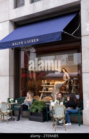 I clienti ai tavoli dei caffè esterni del negozio Ralph Lauren in Bond Street il 27 settembre 2023 a Londra, Regno Unito. Bond Street è una delle strade principali del quartiere dello shopping del West End ed è molto esclusiva. E' stata una strada alla moda per lo shopping fin dal XVIII secolo. Il ricco e ricco negozio qui, soprattutto di alta moda e gioielleria. Foto Stock