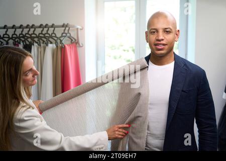 Stilista esperto che sceglie il tessuto per l'abbigliamento del cliente Foto Stock