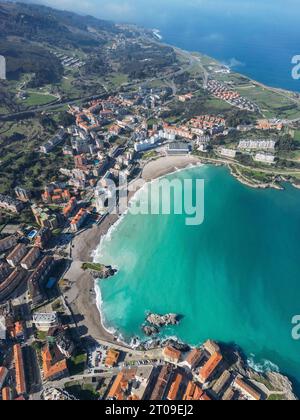 Vista aerea delle onde del mare che si precipitano verso la spiaggia sabbiosa dei Paesi Baschi nelle soleggiate giornate estive Foto Stock