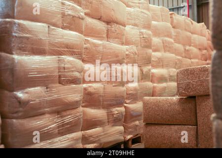 I trucioli di legno imballati sotto vuoto giacciono sui pallet nel magazzino di fabbrica Foto Stock