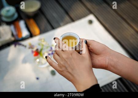 Piccolo tè cinese nelle mani di una donna durante una cerimonia del tè Foto Stock