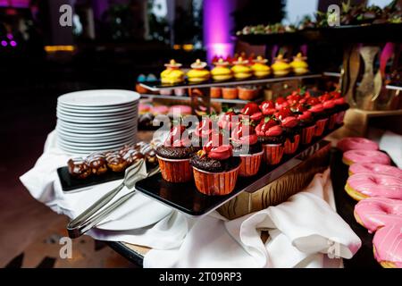 Cupcake al cioccolato con condimenti al tavolo dell'evento Foto Stock