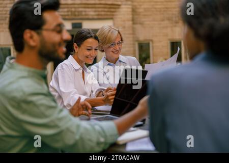 Team creativo che collabora al progetto durante la riunione in un caffè all'aperto. Concezione degli affari Foto Stock