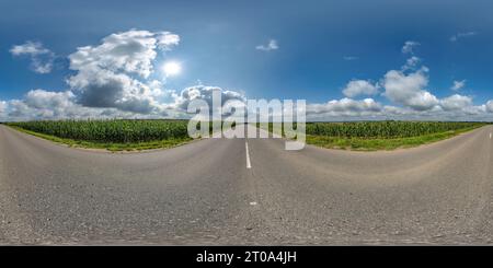 Visualizzazione panoramica a 360 gradi di panorama sferico 360 hdri su una vecchia strada asfaltata tra campi di mais con nuvole e sole sul cielo blu con proiezione uniforme equirettangolare, come skydome r