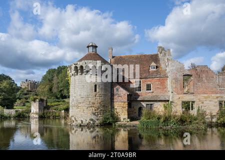 Rovine del castello di Scotney con riflessi d'acqua sul fossato del castello, Lamberhurst, Kent, Regno Unito Foto Stock