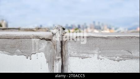 Riparazione dell'impermeabilizzazione dell'unità hvac da vicino su un tetto piatto con lo skyline del centro. Unità aria di compensazione tetto o unità tetto confezionata su un'abitazione o un'unità di comunicazione Foto Stock