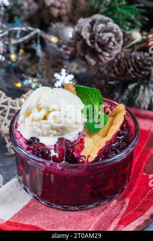 Ciottoli di frutti di bosco in camicia di vetro con gelato, decorazione natalizia su sfondo, verticale Foto Stock