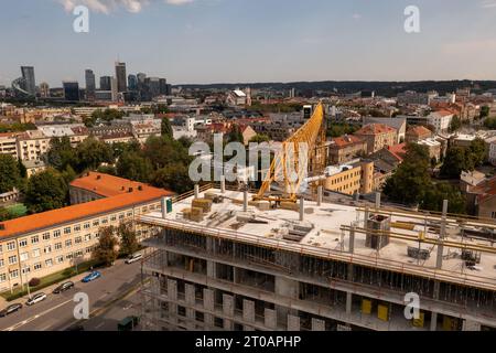 Fotografia con droni di un sito di costruzione di edifici di alto livello da vicino e di lavoratori edili al lavoro Foto Stock