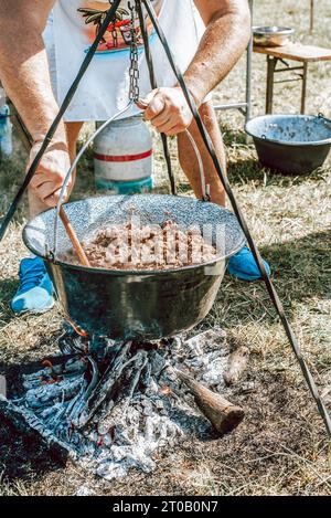 cuocere in un calderone, cuocere il gulasch in un calderone. Foto Stock