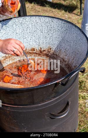 cuocere in un calderone, cuocere il gulasch in un calderone. Foto Stock