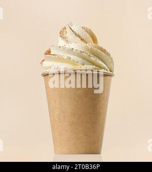 tazza di cappuccino decorata con panna montata e cannella su sfondo di colore beige Foto Stock