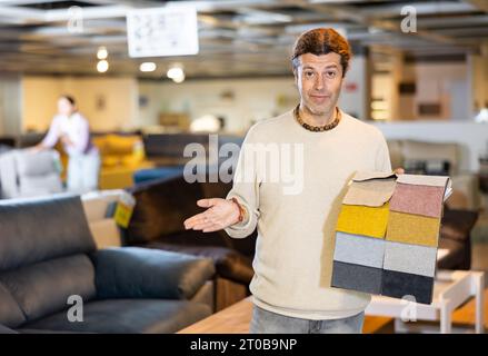 Uomo di mezza età mostra tessuto di tappezzeria Foto Stock