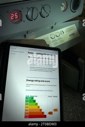 Tablet iPad con EPC per il Regno Unito, classificazione energetica e punteggio, vicino alla caldaia a gas per riscaldamento centralizzato, in proprietà domestica, casa semi-indipendente, Cheshire, Inghilterra, REGNO UNITO Foto Stock