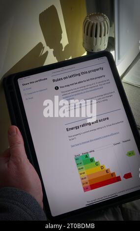 Tablet iPad con EPC per il Regno Unito, classificazione energetica e punteggio, vicino al radiatore di riscaldamento centrale, in proprietà domestica, casa semi-indipendente, Cheshire, Inghilterra, REGNO UNITO Foto Stock