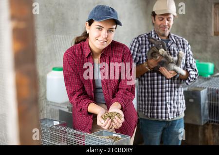 Affari di famiglia - l'uomo e la donna allevano conigli in fattoria Foto Stock