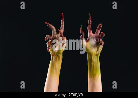 Mani di strega con artigli su sfondo nero. Festa di Halloween Foto Stock