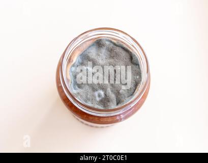 Aprire il vaso con marmellata dolce e muffa su sfondo bianco. Foto Stock