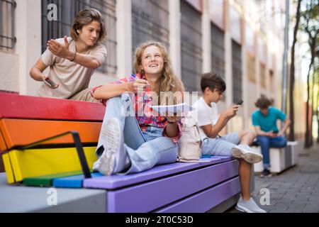 Il ragazzo e la ragazza hanno chiacchierata di divertimento. Guy punta la mano a qualcuno Foto Stock