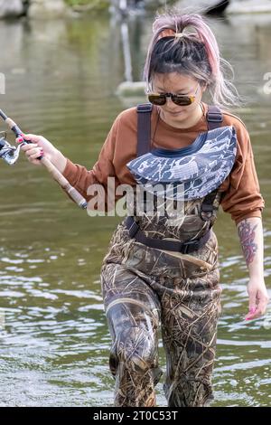 Una giovane ragazza prende il salmone sul fiume Foto Stock