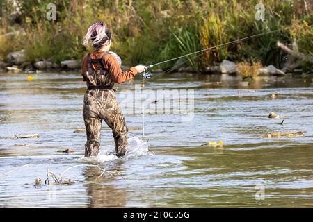 Una giovane ragazza prende il salmone sul fiume Foto Stock