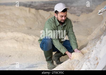 Coltivatore che squatting a mucchio di farina di mais Foto Stock