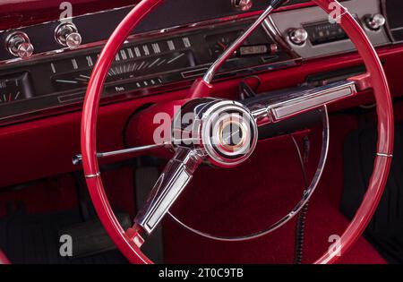 Primo piano sul volante e sulla cabina di pilotaggio di una vecchia auto d'epoca. Immagine in stile retrò di una vecchia autoradio all'interno di un'auto Chevrolet classica, interni rossi - 30 aprile 20 Foto Stock