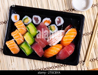 Set di nigiri sushi, uramaki e norimaki in vassoio di plastica Foto Stock