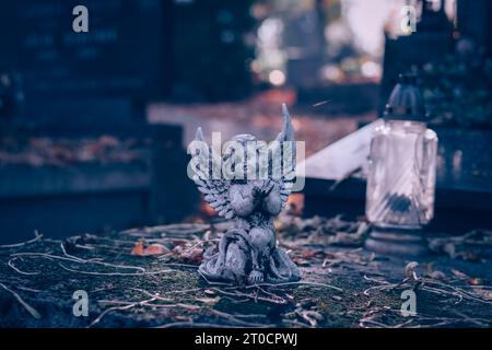 statua dell'angelo custode sulla tomba in triste periodo autunnale Foto Stock