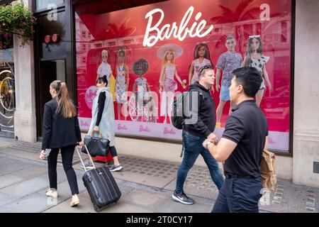 Materiale promozionale per le bambole Barbie nella vetrina del negozio di giocattoli Hamleys il 27 settembre 2023 a Londra, Regno Unito. Barbie è una bambola di moda creata dalla donna d'affari americana Ruth Handler, prodotta dall'azienda di giocattoli americana Mattel e lanciata nel 1959. Il giocattolo è il fiore all'occhiello del marchio Barbie, che include una gamma di bambole e accessori alla moda. Foto Stock