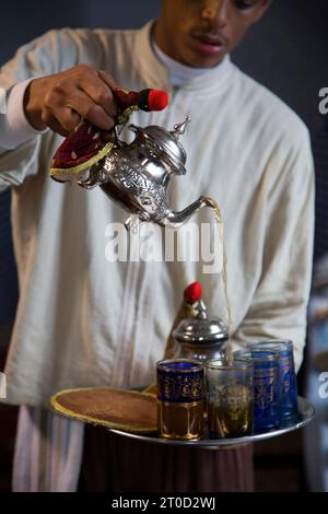 Cameriere che versa il tè al Marhaba Palace, un lussuoso ristorante del palazzo nella città vecchia. Tangeri. Marocco Foto Stock